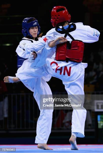 Yang Shu Chun of Chinese Taipei competes with Wu Jingyu of China in the Women's Taekwondo 47kg final match during the 15th Asian Games Doha 2006 at...