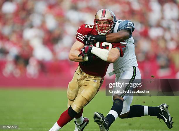 Tight end Eric Johnson of the San Francisco 49ers fights for yardage against linebacker Leroy Hill of the Seattle Seahawks at Monster Park on...