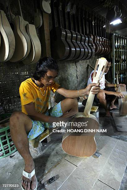 Workers assemble guitars at a private guitar workshop in Lapu-Lapu city, in central province of Cebu, 06 December 2006. Making guitars is a...
