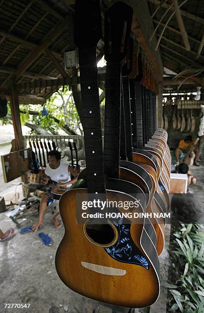 Workers assemble guitars at a private guitar workshop in Lapu-Lapu city, in central province of Cebu, 06 December 2006. Making guitars is a...