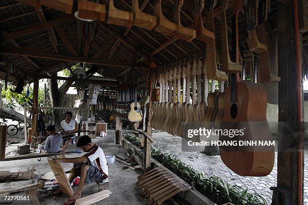 Workers assemble guitars at a private guitar workshop in Lapu-Lapu city, in central province of Cebu, 06 December 2006. Making guitars is a...