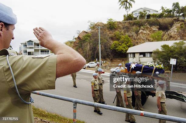 Sergeant from the Army Aviation regiment salutes the coffin containing the body of Black Hawk helicopter Captain Mark Bingley as it is carried from...