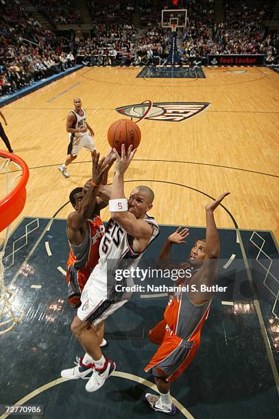 Jason Kidd of the New Jersey Nets shoots in between Amare Stoudemire and Raja Bell of the Phoenix Suns on December 7, 2006 at the Continental...