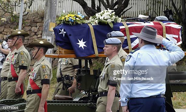 Policeman salutes the coffin containing the body of Black Hawk helicopter pilot Captain Mark Bingley as it is carried from the church at the...