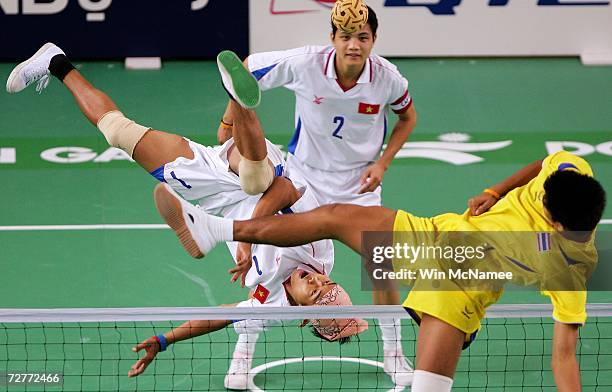 Thailand's Pornchai Kaokaew tries to block the spike of Vietnam's Dinh Kien Trinh as teammate Trung Hieu Do looks on during mens regu Sepaktakraw...