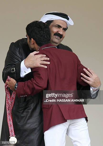 Qatari Emir Sheikh Hamad bin Khalifa al-Thani embraces gold winner Abdulla Ali el-Ejail after winning the gold medal with his fellow teammates...