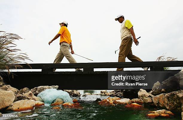Chen Chih Chiang of Chinese Taipei and Michael Bibat of the Philippines walk across a bridge during round one of Men's Golf during day eight of the...
