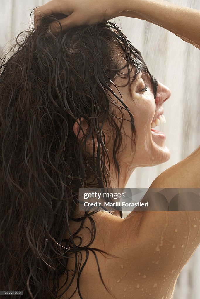 Woman in shower, hands in hair, close-up