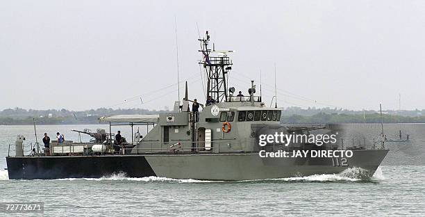 Philippine Navy boat patrols the channel between Cebu city and Mactan island, seen in the background 08 December 2006 as part of the security...