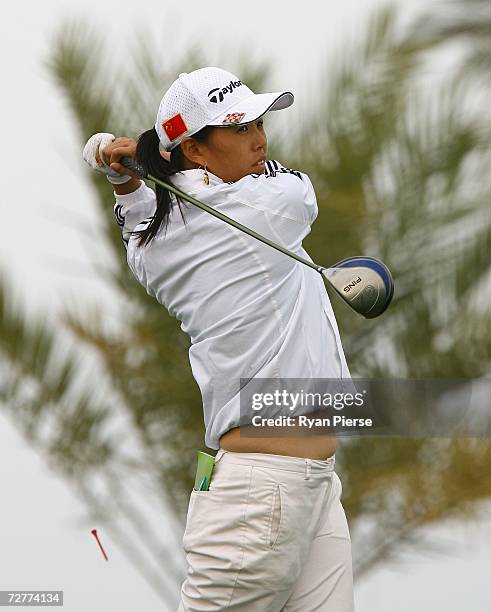 Huang Ping of China hits her driver during round one of Women's Golf during day eight of the 15th Asian Games Doha 2006 at Doha Golf Club on December...