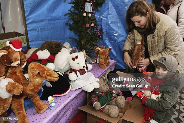 An unemployed single mother and her three-year-old son choose a toy at a special Christmas market for welfare recipients December 8, 2006 in Berlin,...