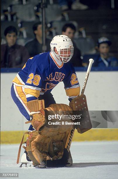 Canadian ice hockey player Greg Millen, goalkeeper for the St. Louis Blues, defends the net during a game, late 1980s.