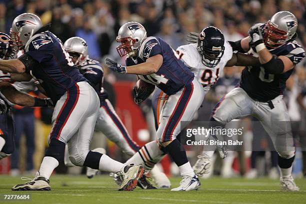 Running back Heath Evans of the New England Patriots runs with a block from guard Logan Mankins against defensive tackle Tommie Harris of the Chicago...