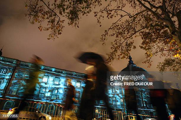 Des personnes passent le 08 decembre 2006 a Lyon devant l'hopital Hotel-Dieu illumine a l'occasion de la 8e Fete des Lumieres. Quatre millions de...