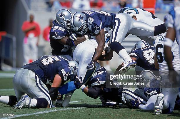 Darren Woodson of the Dallas Cowboys makes the tackle with teammates Barron Wortham and Dexter Coakley during the game against the Carolina Panthers...