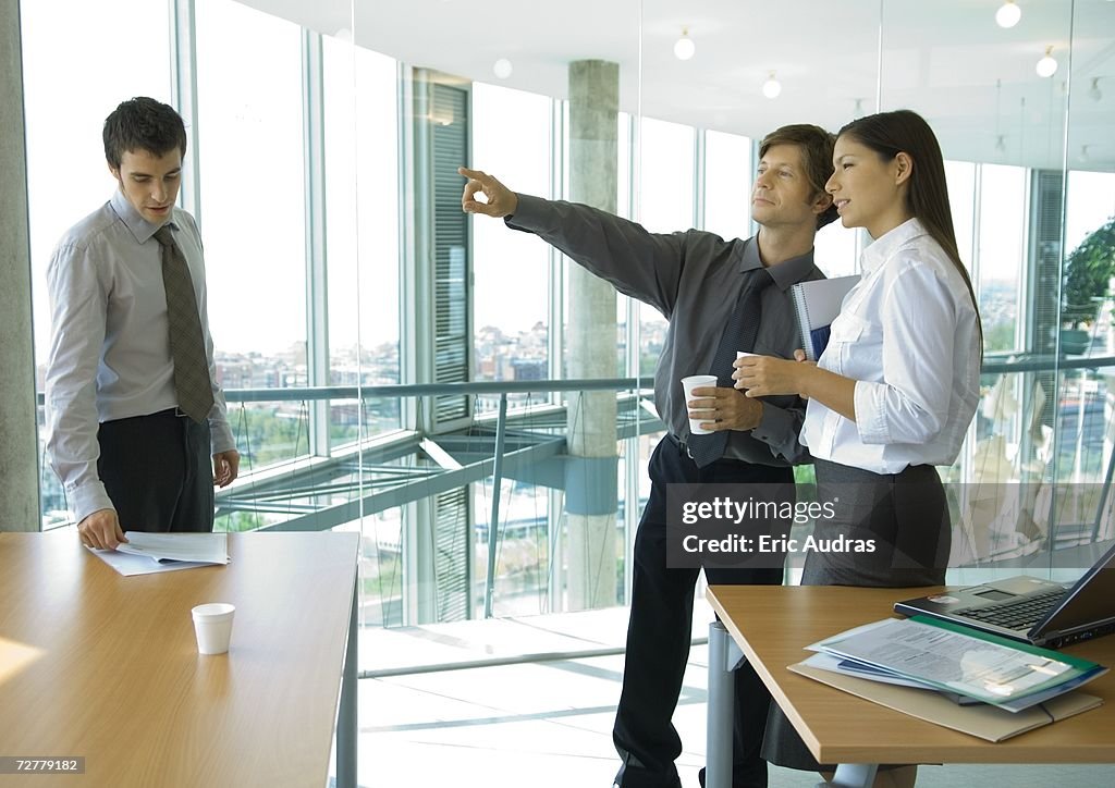 Business colleagues standing with cups of coffee, chatting