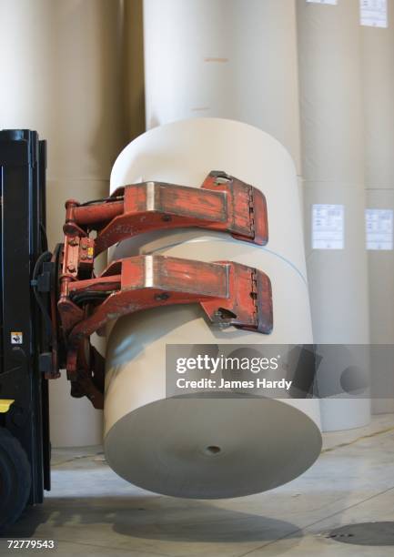 forklift transporting roll of paper in warehouse - bobinas de papel fotografías e imágenes de stock