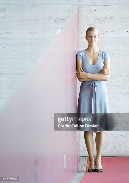 businesswoman standing with arms folded, full length - geschäftsfrau kleid stock-fotos und bilder