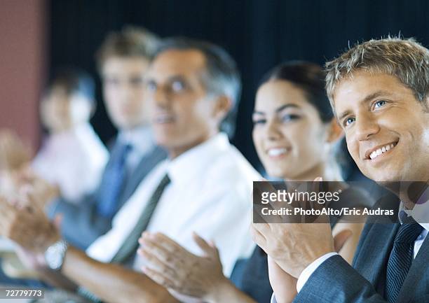 executives sitting in seminar, clapping - accionista fotografías e imágenes de stock