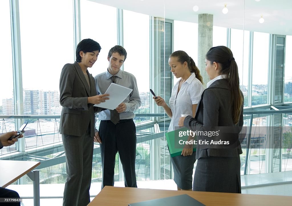 Four office workers standing, talking