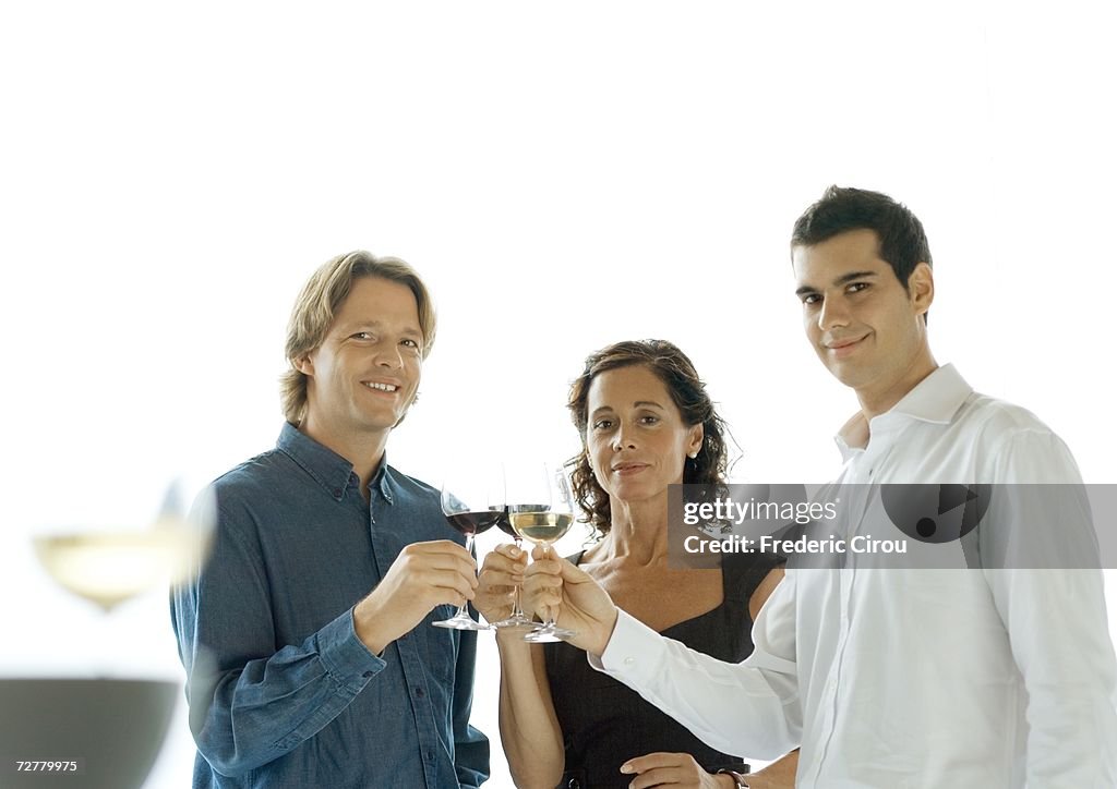 Three people clinking glasses of wine