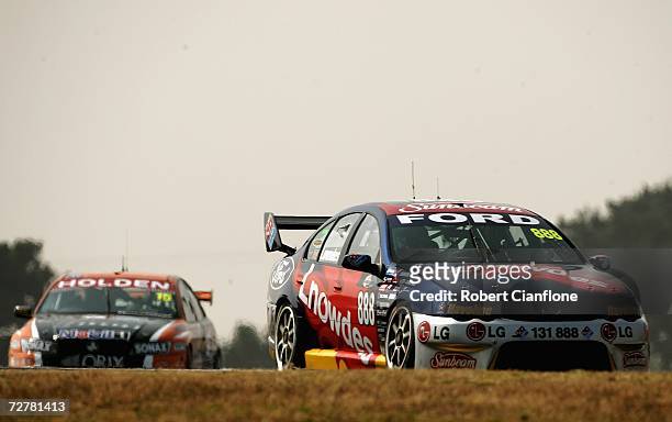Craig Lowndes of Triple Eight Race Engineering is followed by Rick Kelly of the Toll HSV Dealer Team during race one of round 13 of the V8 Supercars...