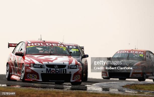 Mark Skaife of the Holden Racing Team holds off Craig Lowndes of Triple Eight Race Engineering and Rick Kelly of the Toll HSV Dealer Team during race...