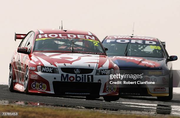 Mark Skaife of the Holden Racing Team holds off Craig Lowndes of Triple Eight Race Engineering during race one of round 13 of the V8 Supercars at the...