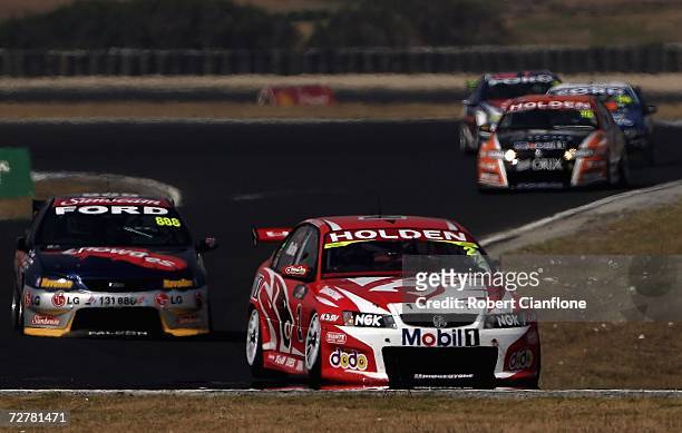 Mark Skaife of the Holden Racing Team holds off Craig Lowndes of Triple Eight Race Engineering and Rick Kelly of the Toll HSV Dealer Team during race...