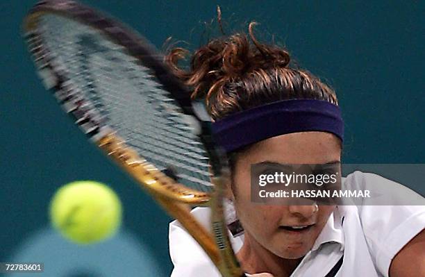 India's tennis player Sania Mirza returns a shot to Murad Inoyatov and Dilyara Saidhodjaeva of Uzbekistan during their mixed doubles - round of 16...