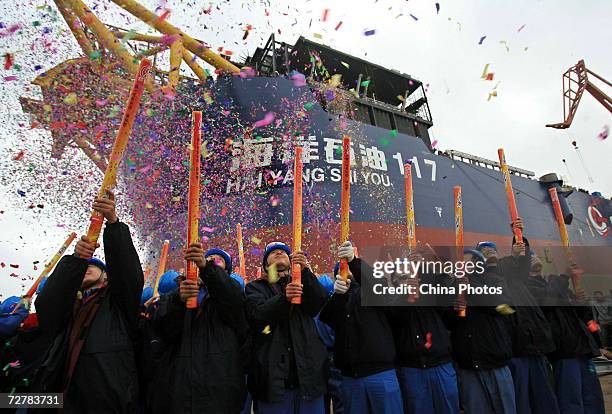 Company officials cheer during the launching ceremony of floating production storage off-loading vessel "Hai Yang Shi You 117" at Shanghai Waigaoqiao...