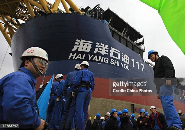 Workers attend the launching ceremony of floating production storage off-loading vessel "Hai Yang Shi You 117" at Shanghai Waigaoqiao Shipbuilding...