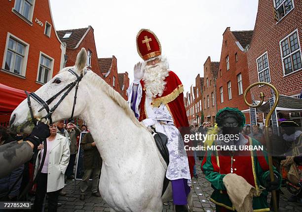 Sinterklaas and his Zwarte Pieten walk through the Dutch Quarter of Potsdam, eastern Germany, 09 December 2006. According to the Dutch holiday...