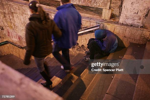 Couple walks pass a homeless child December 9, 2006 in Bucharest, Romania. Romania has had a crisis with homeless street children since the days of...