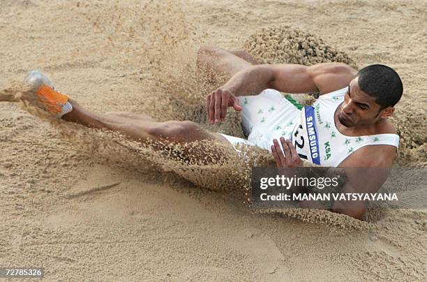 Saudi Arabia's Hussein Taher Al Saba lands in the men's long jump final on the second day of the athletics competition for the 15th Asian Games at...