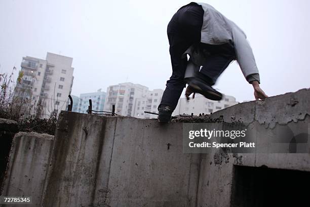 Teenager climbs out of the underground shelter he is living in with six other teens and children December 9, 2006 in Bucharest, Romania. Romania has...