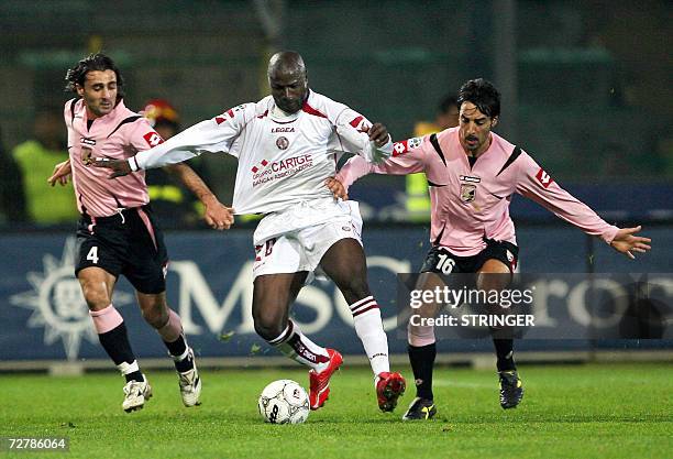 Livorno's forward Ibrahim Bakayoko vies with Palermo's midfilders Giacomo Tedesco and Mattia Cassani during their Italian Serie A football match at...