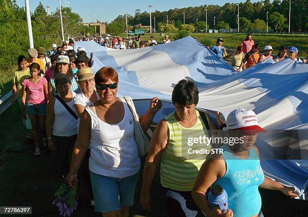 Habitantes de la ciudad argentina de Concordia sostienen una bandera gigante en el acceso al puente que une con la ciudad de Salto, en Uruguay, el 09...