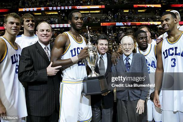 John Wooden presents the UCLA Bruins the trophy after defeating the Texas A&M Aggies at the John R. Wooden Classic at the Honda Center December 9,...