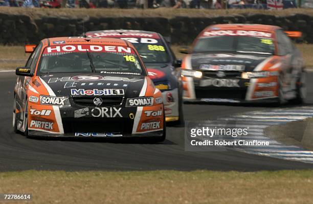 Garth Tander of the Toll HSV Dealer Team holds off Craig Lowndes of Triple Eight Race Engineering as Rick Kelly of the Toll HSV Dealer Team follows...