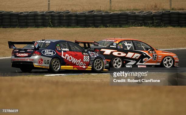 Craig Lowndes of Triple Eight Race Engineering is blocked by Garth Tander of the Toll HSV Dealer Team during race two of round 13 of the V8 Supercars...