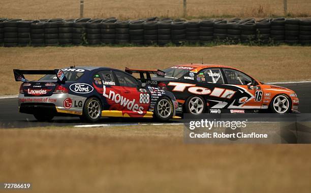 Craig Lowndes of Triple Eight Race Engineering is blocked by Garth Tander of the Toll HSV Dealer Team during race two of round 13 of the V8 Supercars...