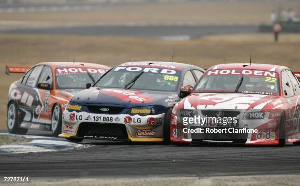 Rick Kelly of the Toll HSV Dealer Team nudges Craig Lowndes of Triple Eight Race Engineering causing him to spin into Todd Kelly of the Holden Racing...