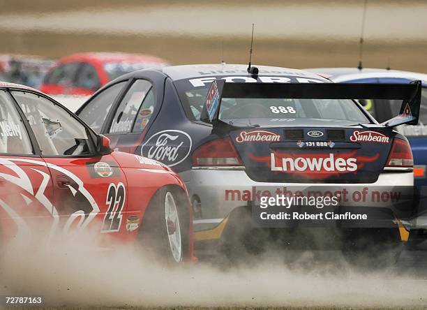 Rick Kelly of the Toll HSV Dealer Team nudges Craig Lowndes of Triple Eight Race Engineering causing him to spin into Todd Kelly of the Holden Racing...