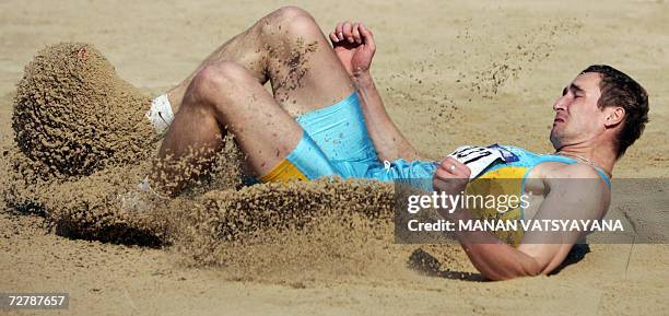 Kazakhstan's Dmitriy Karpov makes a landing in the men's decathlon long jump event on the third day of the athletics competition for the 15th Asian...