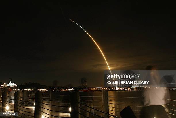 Orlando, UNITED STATES: The Space Shuttle Discovery as viewed from Walt Disney World Florida, streaks through the night sky 09 December 2007 with...