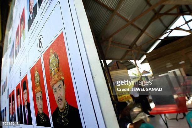 Banda Aceh, INDONESIA: Election officials and Acehnese youths rests inside a polling station in Banda Aceh, 10 December 2006, a day before the...