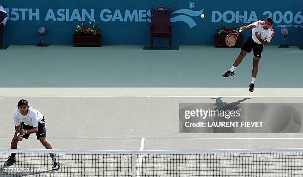 Kuwait's Mohammed Ghareeb serves whlie his partner Ahmad Mohammad looks on during their game against India's Leander Paes and Mahesh Bhupathi in the...