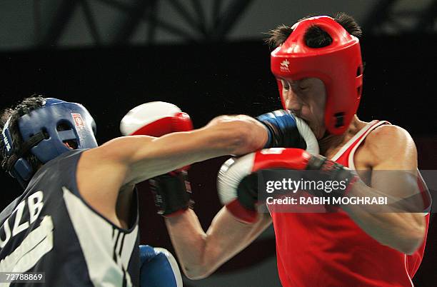 Bahodirjon Sultanov of Uzbekistan punches Kim Song Guk of North Korea in the men's boxing feather 57kg quarter-final during the 15th Asian Games in...