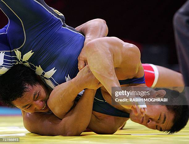 Shingo Matsumoto of Japan fights with Kim Jung Sub of South Korea during their 84 kg Greco-Roman wrestling preliminary battle at the 15th Asian Games...